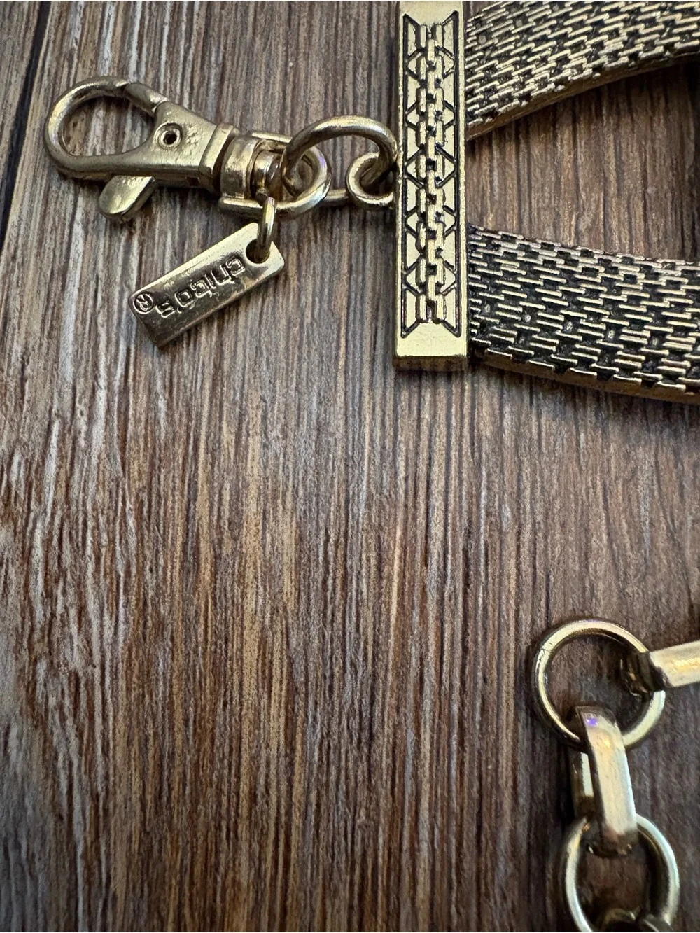 Vingold-tone statement belt featuring textured interlocking links and a chain